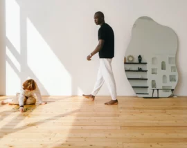 Man walking past child playing on floor
