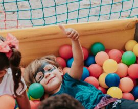 Boy with facepaint on playing in ballpit